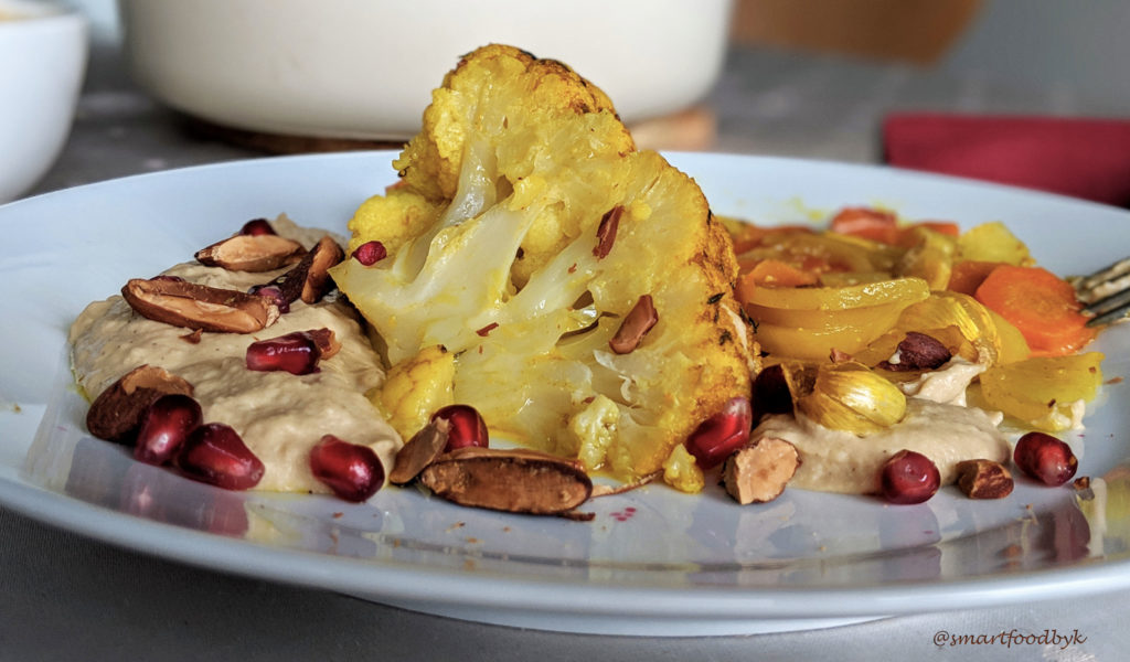 Roti de chou-fleur servi avec de l'hummus maison, amandes grillées et des grains de grenade. Une combinaison irresistible ;)